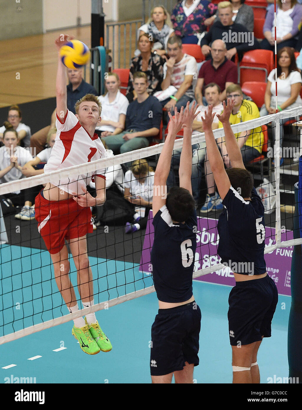 L'homme William Van Wingerden d'Angleterre Junoir passe le ballon devant les Scotland West Boys Chris Taylor et Fraser Dunlop, dans la finale du volley-ball, lors des Jeux scolaires de Sainsbury en 2014 au Sugden Centre, à Manchester. Banque D'Images