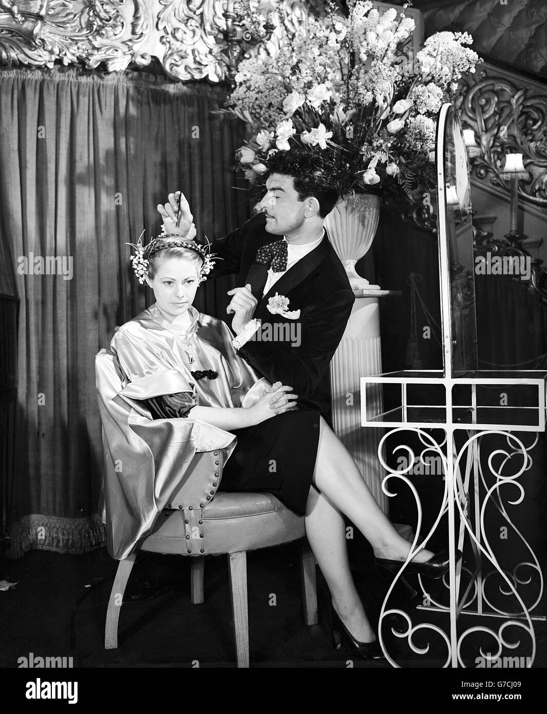 Raymond travaille avec détours sur une coiffure présentée dans sa coiffure de la parade de Pâques de 1951 à Care de Paris, Coventry Street, Londres. Il l'appelle « Parade de Pâques » et a manqué Stella CRIBE comme son modèle. Banque D'Images