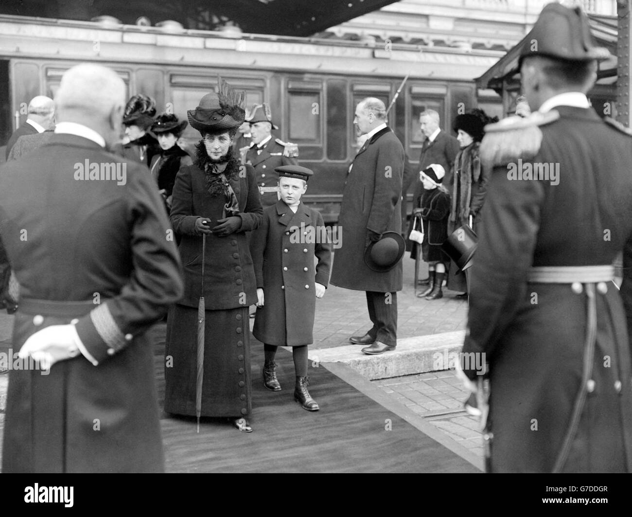 La reine Alexandra et le prince OLAF de Norvège embarqurent à bord du yacht royal à Calais. La reine Maud de Norvège et la princesse Victoria sont vues en arrière-plan. Banque D'Images