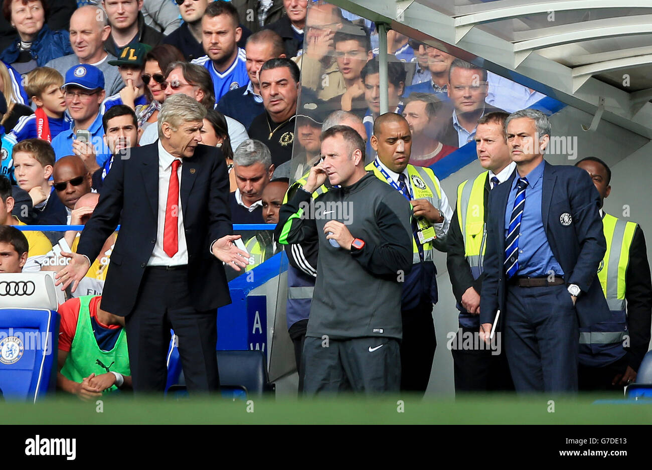 Arsene Wenger, gestionnaire de l'arsenal (à gauche), en discussion avec le quatrième responsable officiel Jon Moss (au centre) sur la ligne de contact, alors que Jose Mourinho, gestionnaire de Chelsea (à droite), regarde pendant le match de la Barclays Premier League à Stamford Bridge, Londres. Banque D'Images