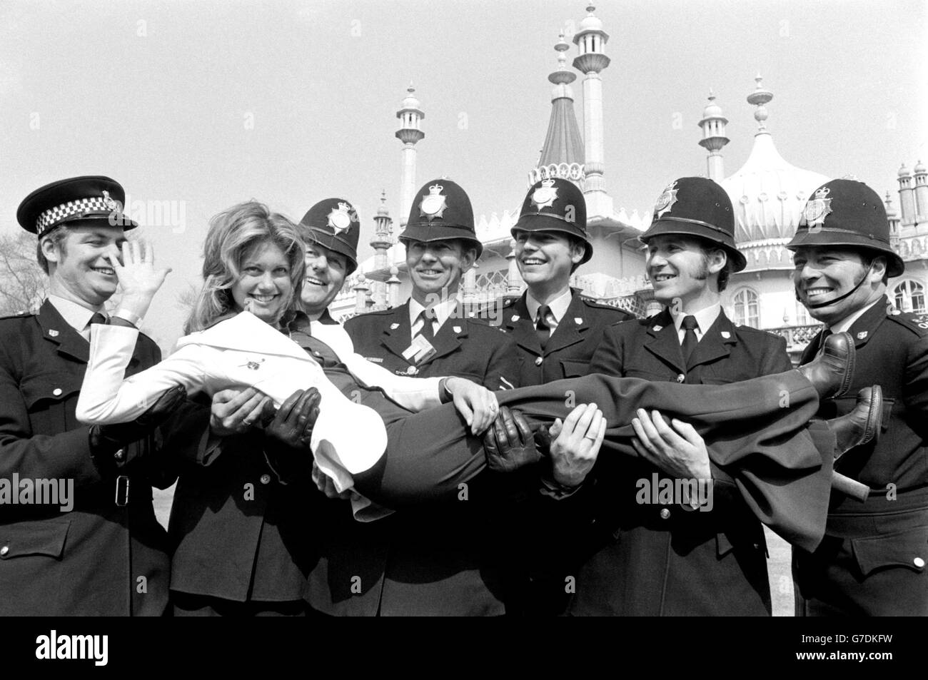 Olivia Newton-John pose avec des policiers à Brighton, où elle répète le concours Eurovision de la chanson qui se déroule au Dome dans la station Sussex. Banque D'Images