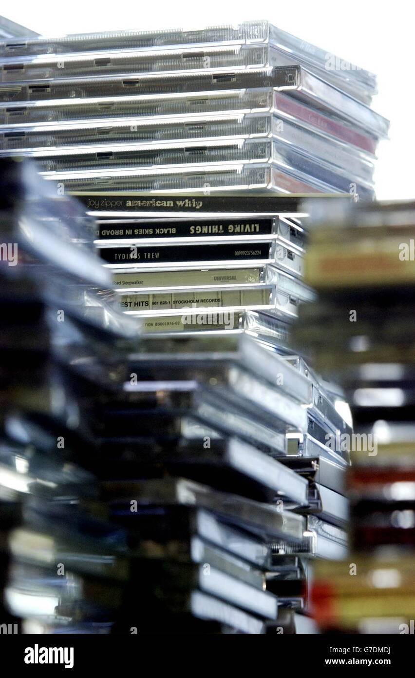 Une pile de disques compacts est placée en face de la musique 'impressario' Pete Waterman, alors qu'il assiste à une conférence de presse dans les bureaux de l'industrie phonographique britannique dans le centre de Londres. Le BPI et son homologue international l'IFPI a annoncé une escalade majeure de leur campagne contre le firesharing illégal, ciblant les principaux téléchargeurs qui rendent illégalement musuc copieux disponibles sur Internet. Banque D'Images