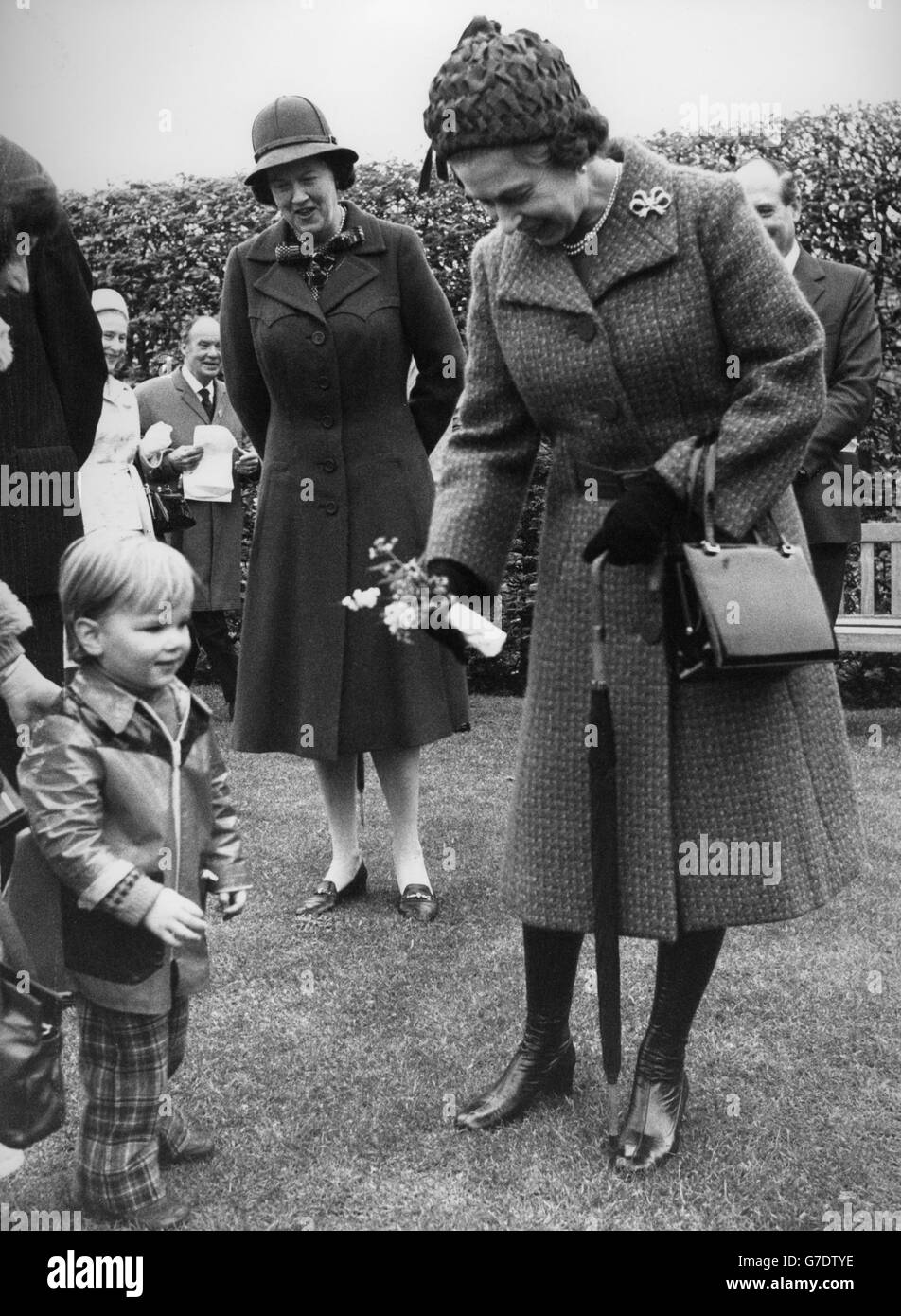 La reine Elizabeth II reçoit une chienne de la part de Roddy Black, deux ans, de Woking lors d'une visite au jardin de la Royal Horticultural Society à Wisley. Banque D'Images