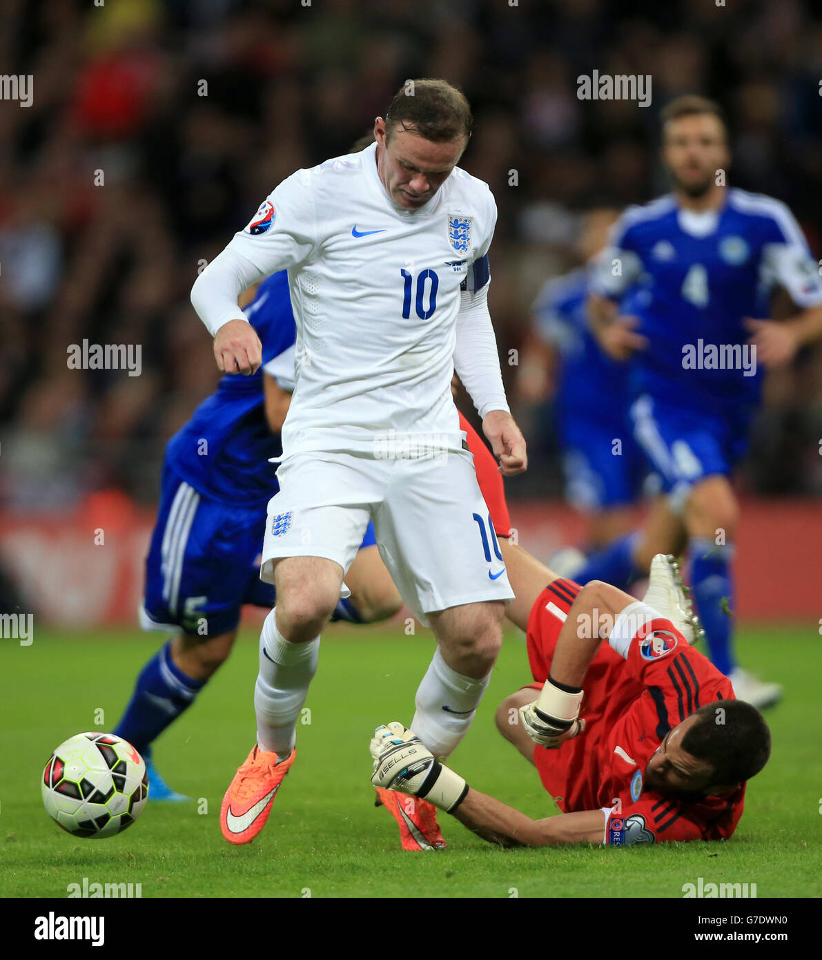 Le Wayne Rooney (à gauche) d'Angleterre s'emmêle avec le gardien de but de Saint-Marin Aldo Simoncini (à droite) lors du match de qualification de l'UEFA Euro 2016 au stade Wembley, Londres. Banque D'Images
