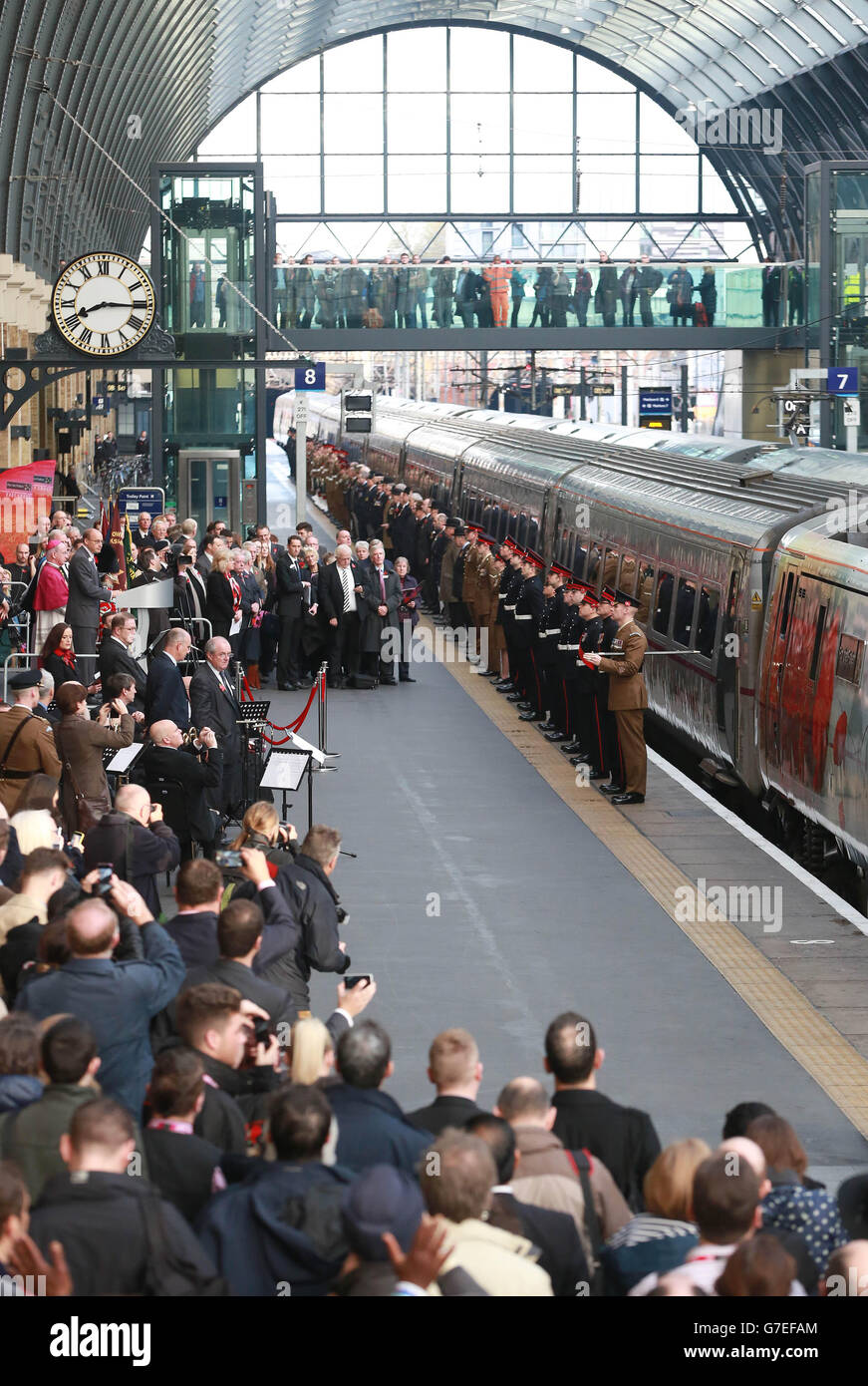 Le personnel militaire en service et vétéran effectue une garde d'honneur lors d'un événement en souvenir avec la locomotive de classe 91 spécialement livrée de la côte est, « pour les morts » (numéro 91111) à la gare de King's Cross à Londres. Banque D'Images