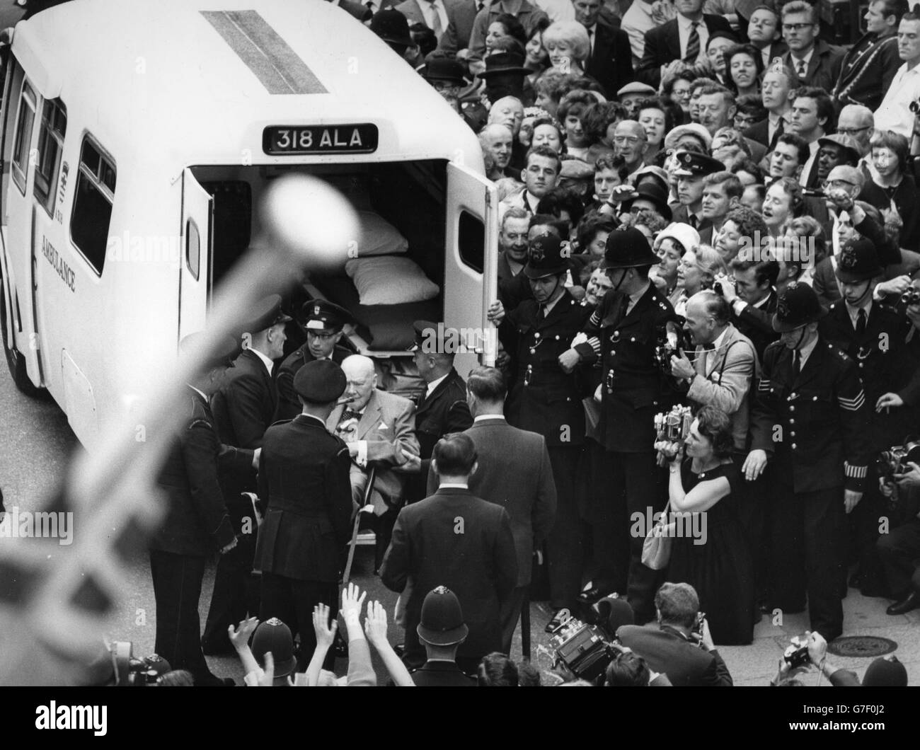 Sir Winston Churchill, 87 ans, est aidé dans une ambulance en attente à la sortie de l'hôpital Middlesex à Londres. Il a passé 54 jours à l'hôpital pour se remettre d'une blessure aux cuisses pendant ses vacances dans le sud de la France. Banque D'Images