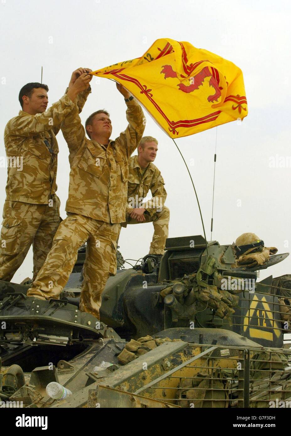 Steven Airzee, 26 ans, de Fife, aide Lee Kenny, 24 ans, de Kinross, et Gary Spence à accrocher un drapeau écossais sur le lion rampant d'un transport blindé guerrier du 1er Bataillon Black Watch (A Company) avant de déployer une patrouille de deux jours depuis Camp Dogwood, en Irak. Banque D'Images