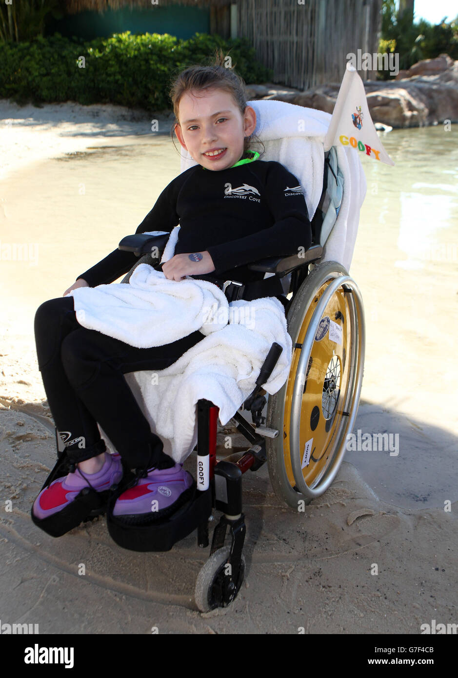 Maisy Gallagher-Horwood (gilet de sauvetage bleu) d'Oxford après une baignade avec un dauphin lors du voyage caritatif DreamFlight à Discovery Cove à Orlando, en Floride. Banque D'Images