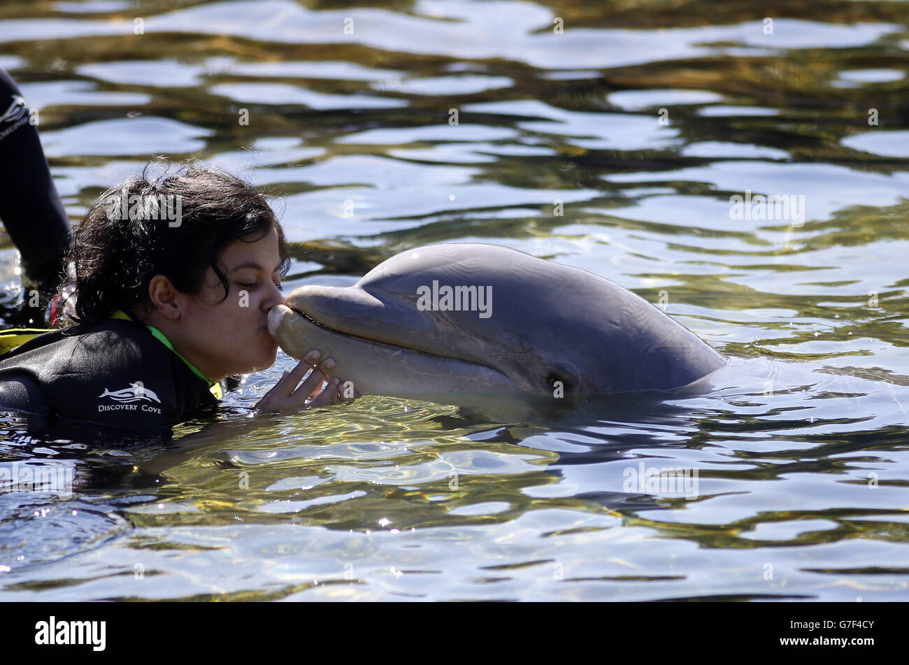 Sara Moosa, de Bolton, embrasse un dauphin lors du voyage caritatif DreamFlight à Discovery Cove à Orlando, en Floride. Banque D'Images