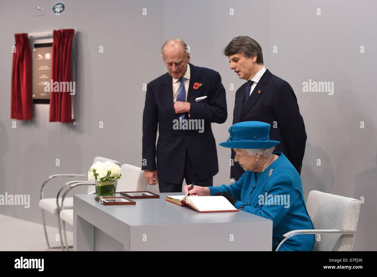 La reine Elizabeth II signe le livre de visite aux côtés du duc d'Édimbourg et du Dr Ralf Speth, directeur général de Jaguar Land Rover, après l'ouverture officielle du nouveau centre de fabrication de moteurs Jaguar Land Rover à Wolverhampton pour ouvrir officiellement l'usine. Banque D'Images