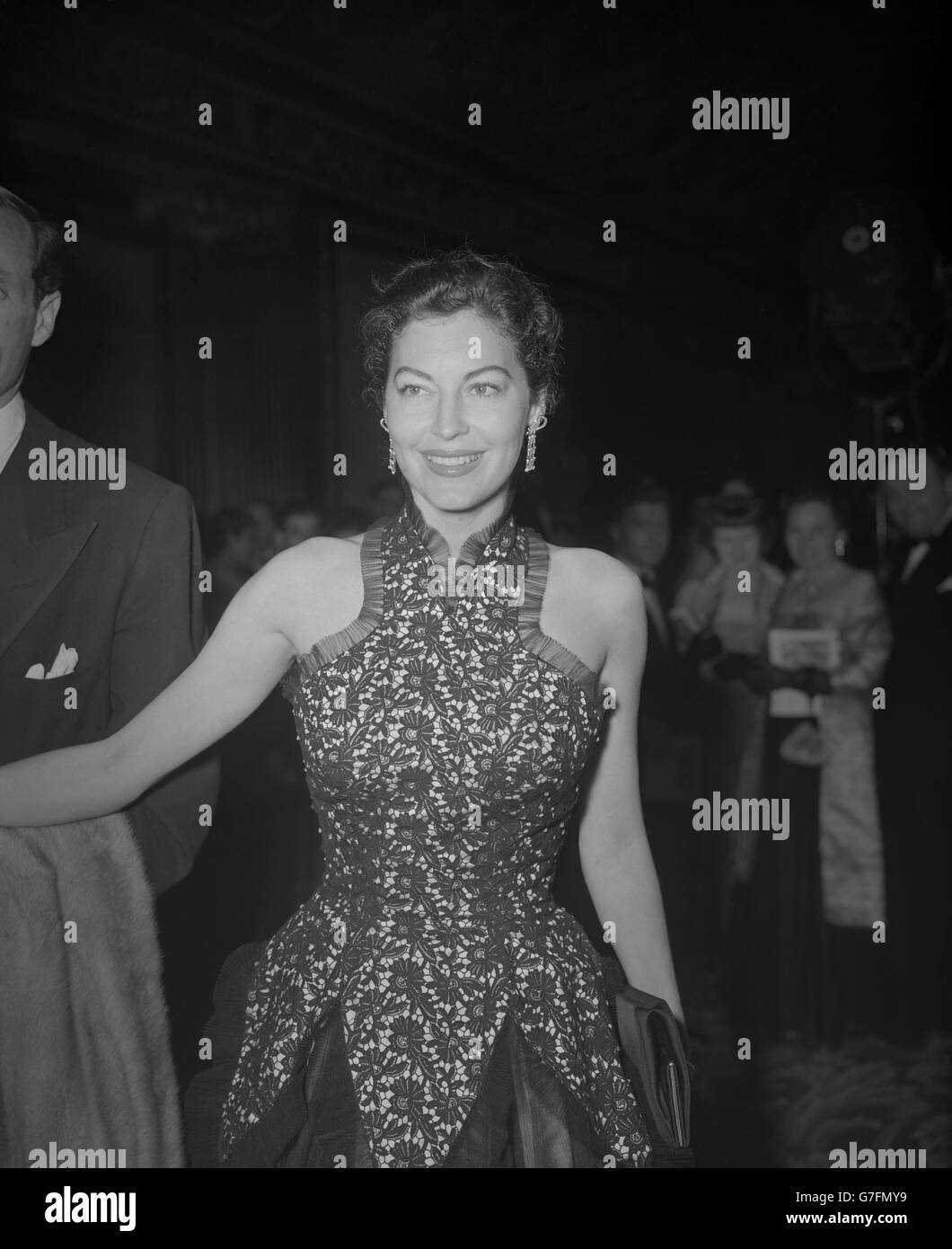 L'actrice hollywoodienne Ava Gardner, vêtue d'une robe à dentelle, s'est coupée aux épaules et bordée de filet, alors qu'elle assistait à la première mondiale caritative du film « The Red Beret » - Story of Britain's Airborne Forces - à l'Empire Theatre, Leicester Square, Londres. Banque D'Images