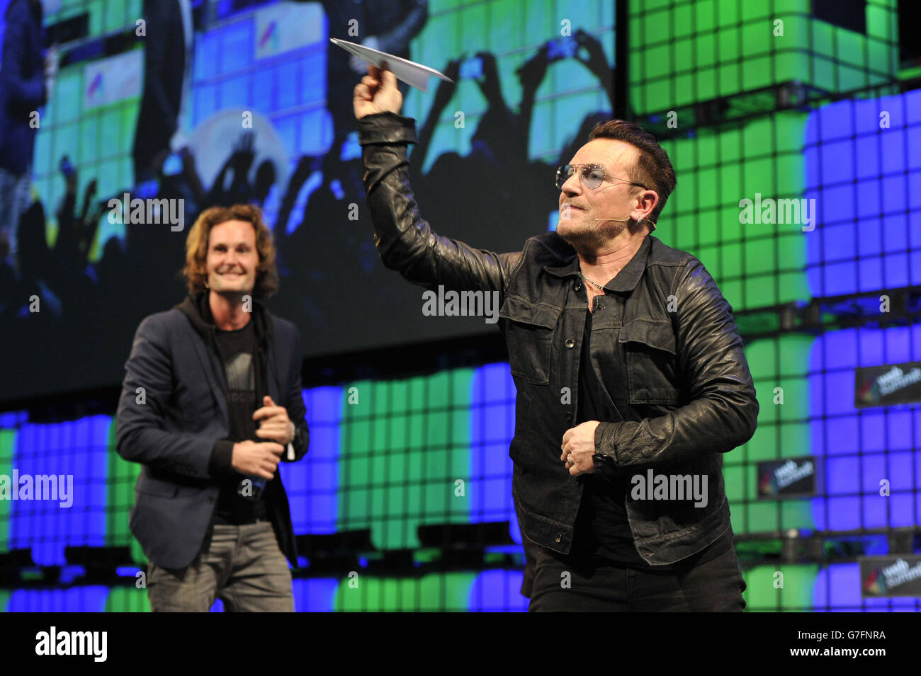 Bono de U2 lance un avion en papier dans le public pendant la troisième journée du Sommet Web 2014 au RDS de Dublin. Banque D'Images