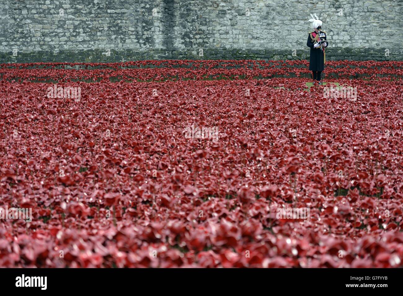 Les noms des soldats britanniques et coloniaux qui ont été tués pendant la première Guerre mondiale sont lus parmi l'installation d'art "Blood balayed Lands and Seas of Red" par l'artiste Paul Cummins à la Tour de Londres. Banque D'Images