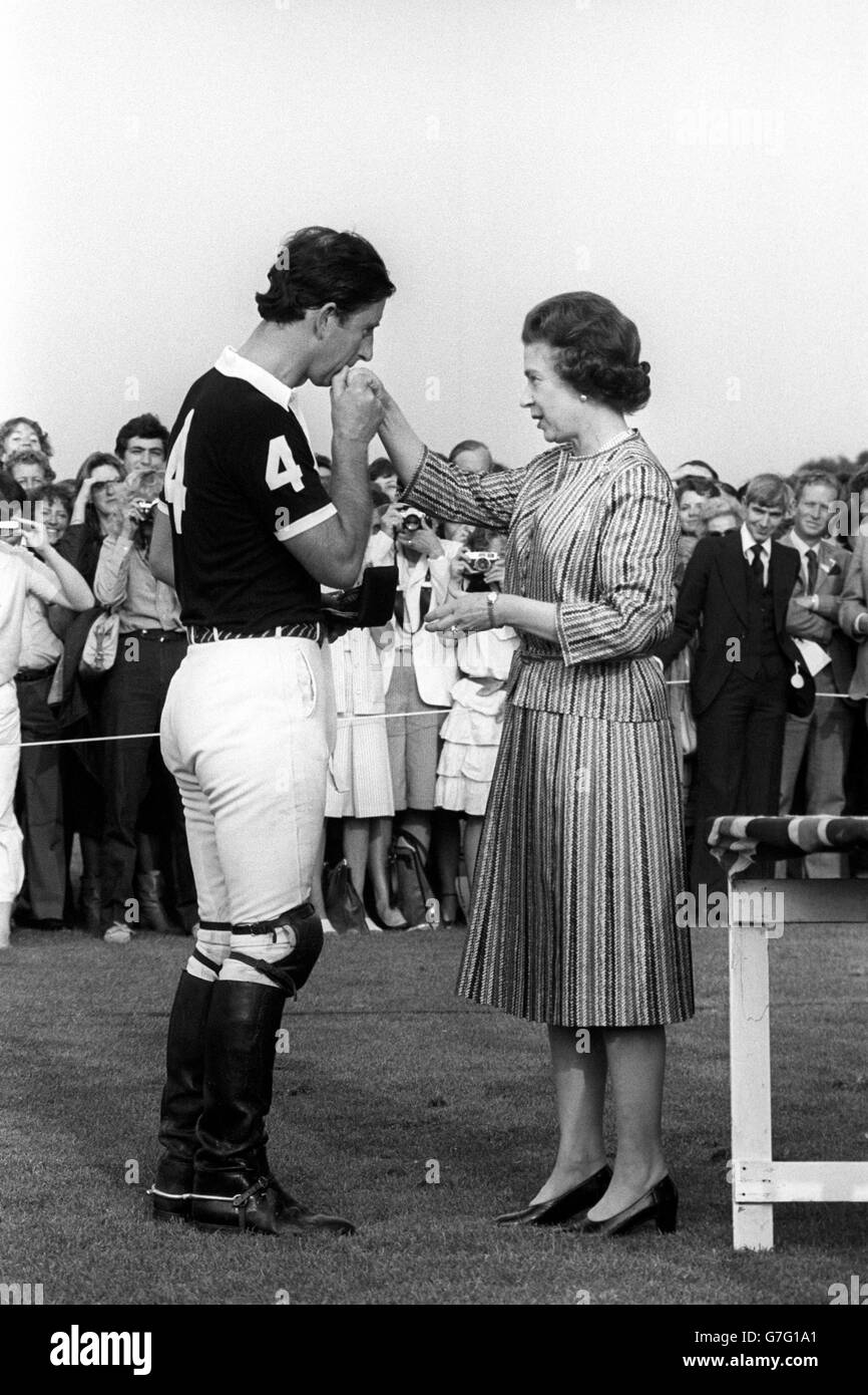 Le Prince de Galles embrasse la main de sa mère après qu'elle lui ait remis sa médaille de deuxième place pour le polo au Windsor Great Park. Banque D'Images