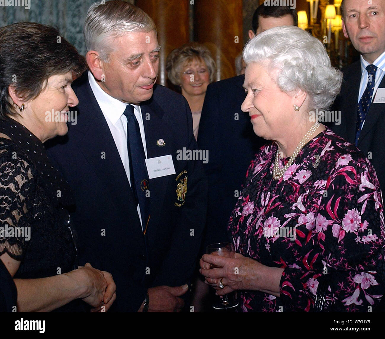 La reine Elizabeth II de Grande-Bretagne rencontre William King d'Irlande du Nord, qui a été invité pour ses services de labour en compétition lors d'une réception de Noël au Palais de Buckingham. La Reine lance une fête de Noël pour les hauts-fliers de 2004. Parmi les 500 invités figurent les héros méconnus de la charité et du travail communautaire ainsi que quelques noms célèbres. Banque D'Images