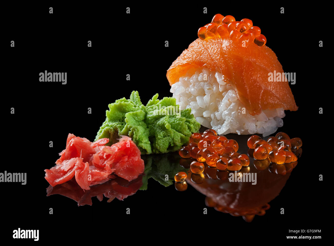 Sushi avec du caviar rouge, wasabi, le gingembre sur le fond de verre noir Banque D'Images