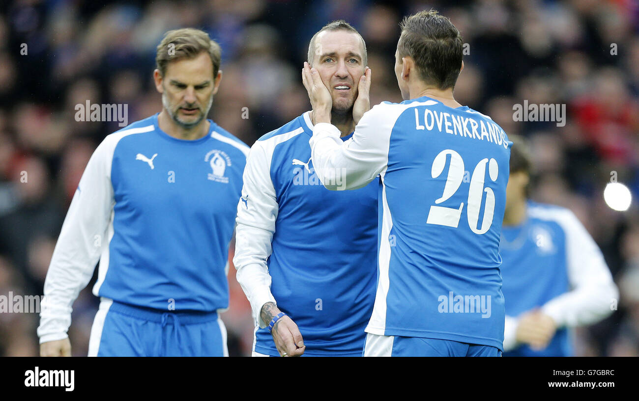 Fernando Ricksen est accueilli par Peter Lovenkrands alors qu'il s'en va pour saluer la foule avant son match d'hommage au stade Ibrox. Banque D'Images