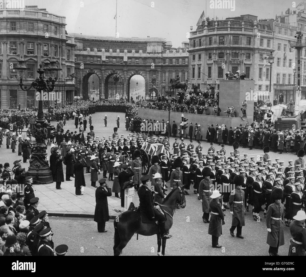 La cortège traverse Trafalgar Square en passant de Westminster Hall à la cathédrale Saint-Paul pendant les funérailles d'État de Sir Winston Churchill. En arrière-plan est Admiralty Arch. Banque D'Images