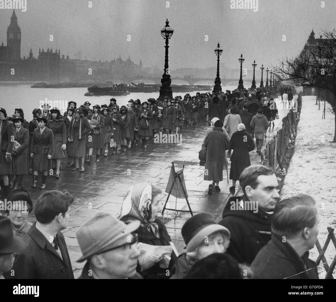 Un groupe de lycéennes fait partie de la longue file d'attente en attendant de déposer dans le Westminster Hall pour le mensonge dans l'état de Sir Winston Churchill. Banque D'Images