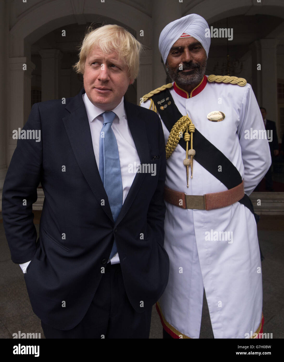 Le maire de Londres Boris Johnson est rencontré par le portier, Narajan, à l'hôtel Raffles de Singapour, avant de s'adresser à la Chambre de commerce britannique de Singapour. Banque D'Images