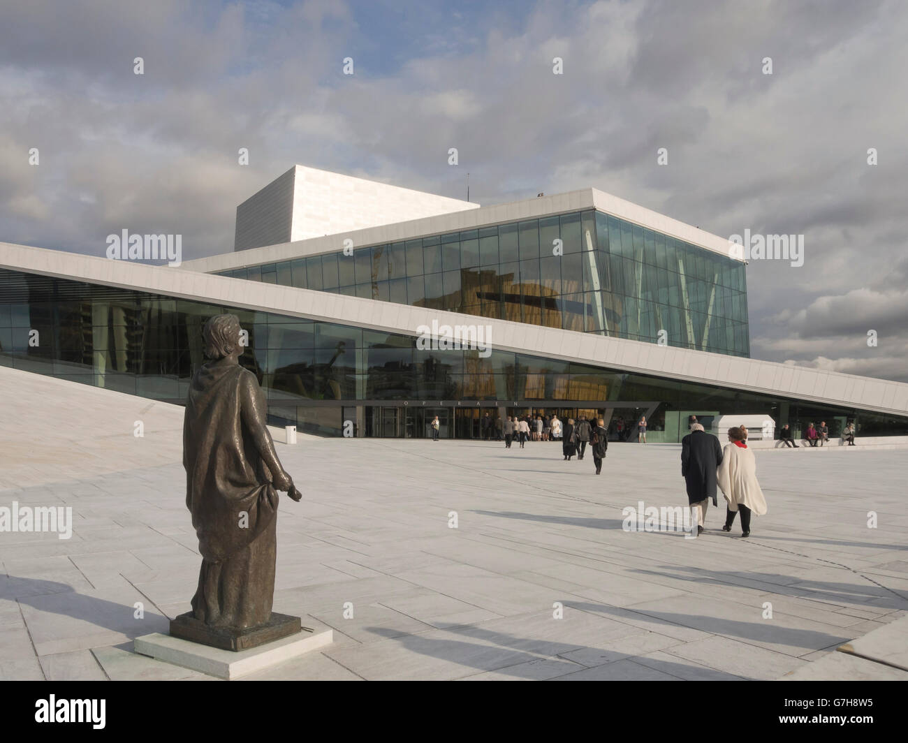 Oslo, Norvège, le célèbre Opéra national par les architectes Snohetta, façade d'entrée, le soir arrivant de l'auditoire Banque D'Images