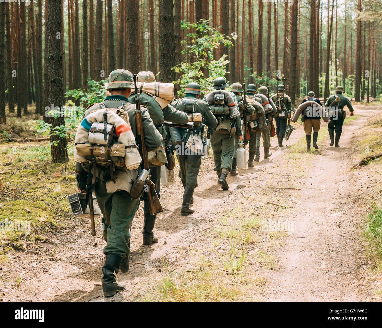 De reconstitution historique non identifié, habillé en soldat de la Wehrmacht allemande à pied dans la forêt d'été Banque D'Images