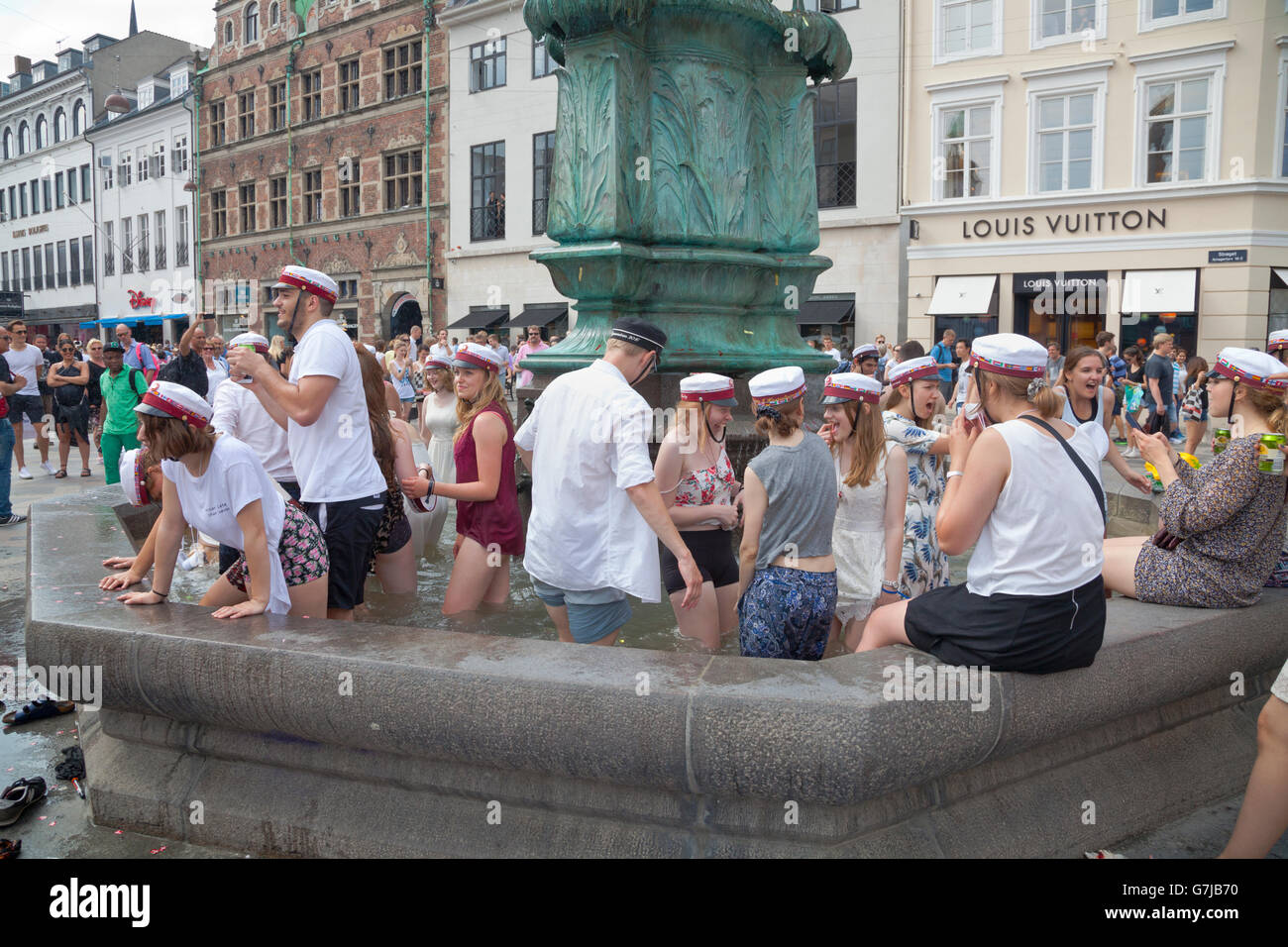 Les étudiants danois célèbrent leur diplôme de lycée et de grammaire avec la plongée traditionnelle dans la fontaine Stork de Stroeget à Copenhague. Banque D'Images