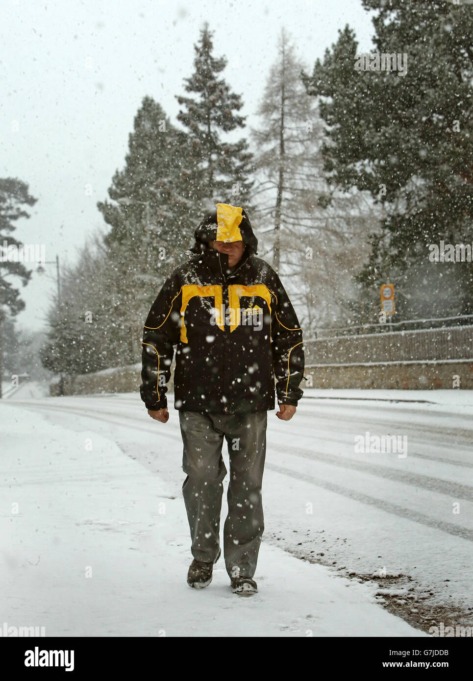 Un homme marche le long de l'A93 près de Braemar, dans l'Aberdeenshire, alors que le temps hivernal a balayé le Royaume-Uni, avec des voyageurs laissés bloqués comme de lourdes routes couvertes de neige et ont forcé deux aéroports à fermer. Banque D'Images