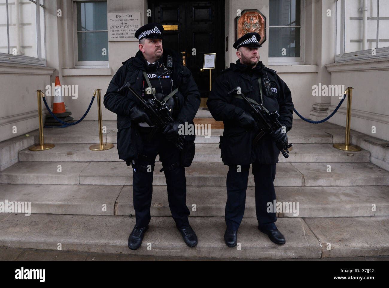 Police armée devant l'ambassade de France à Londres après l'attentat terroriste d'hier à Paris contre le magazine satirique français Charlie Hebdo. Banque D'Images