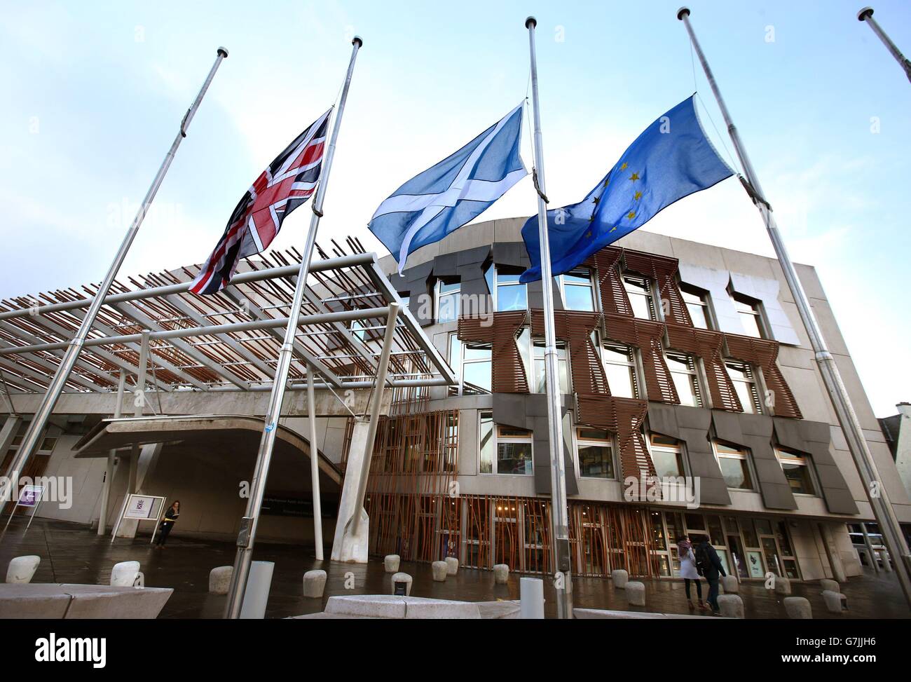 Un drapeau de l'Union, un Saltyre et le drapeau de l'Union européenne en Berne devant le Parlement écossais d'Édimbourg pour honorer les victimes de l'attaque du magazine satirique Charlie Hebdo à Paris. Banque D'Images