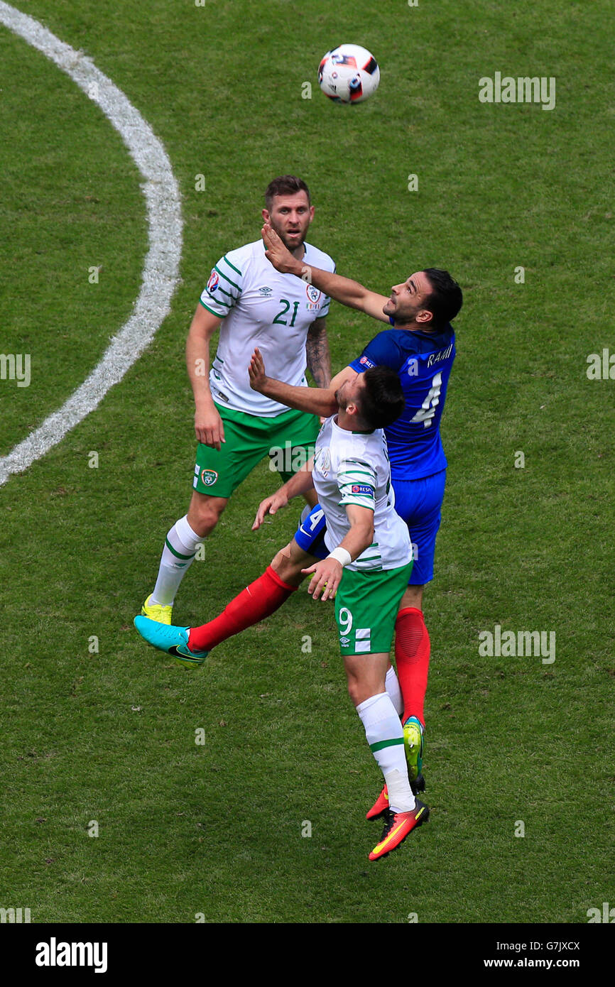 La République d'Irlande Shane Long (en bas) et le français Adil Rami (centre) bataille pour la balle pendant la série de 16 match au Stade de Lyon, Lyon. Banque D'Images