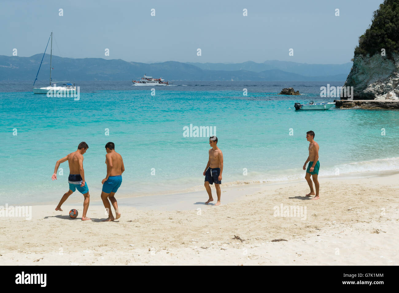 Groupe de jeunes hommes jouent au football sur la plage de sable magnifique Vrika, sur la petite île Antipaxos, îles Ioniennes, Grèce, Europe Banque D'Images