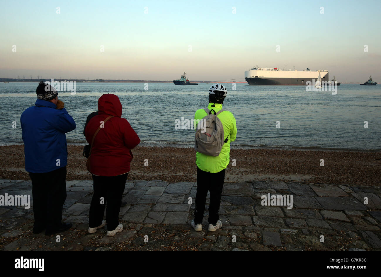 Les membres du public regardent de Calshot dans le Hampshire alors que le porte-voiture Hoegh Osaka est remorqué dans le port de Southampton après que les salves aient réussi à réduire sa liste à cinq degrés. Banque D'Images