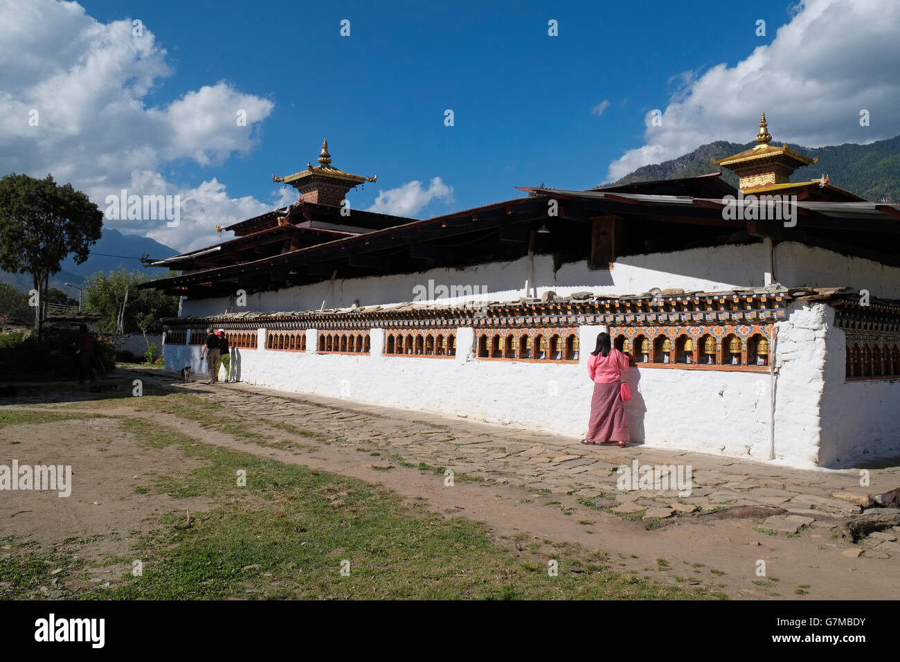 Un adorateur de l'roues de prière à l'arrière du Kyichu Lhakhang temple, Paro, Bhoutan. Banque D'Images