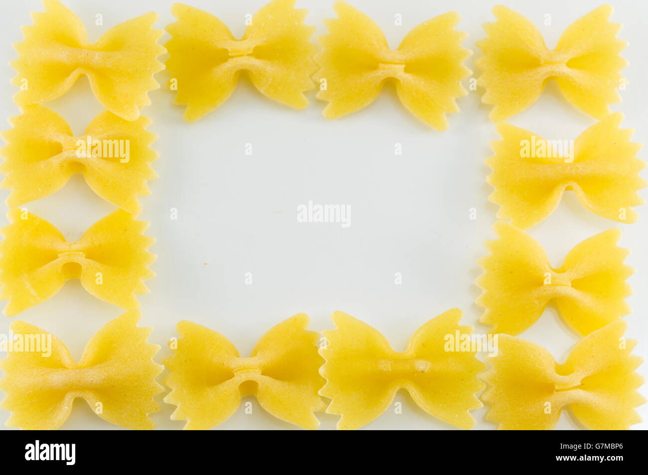 Pâtes farfalle formant des formes sur un fond blanc Banque D'Images