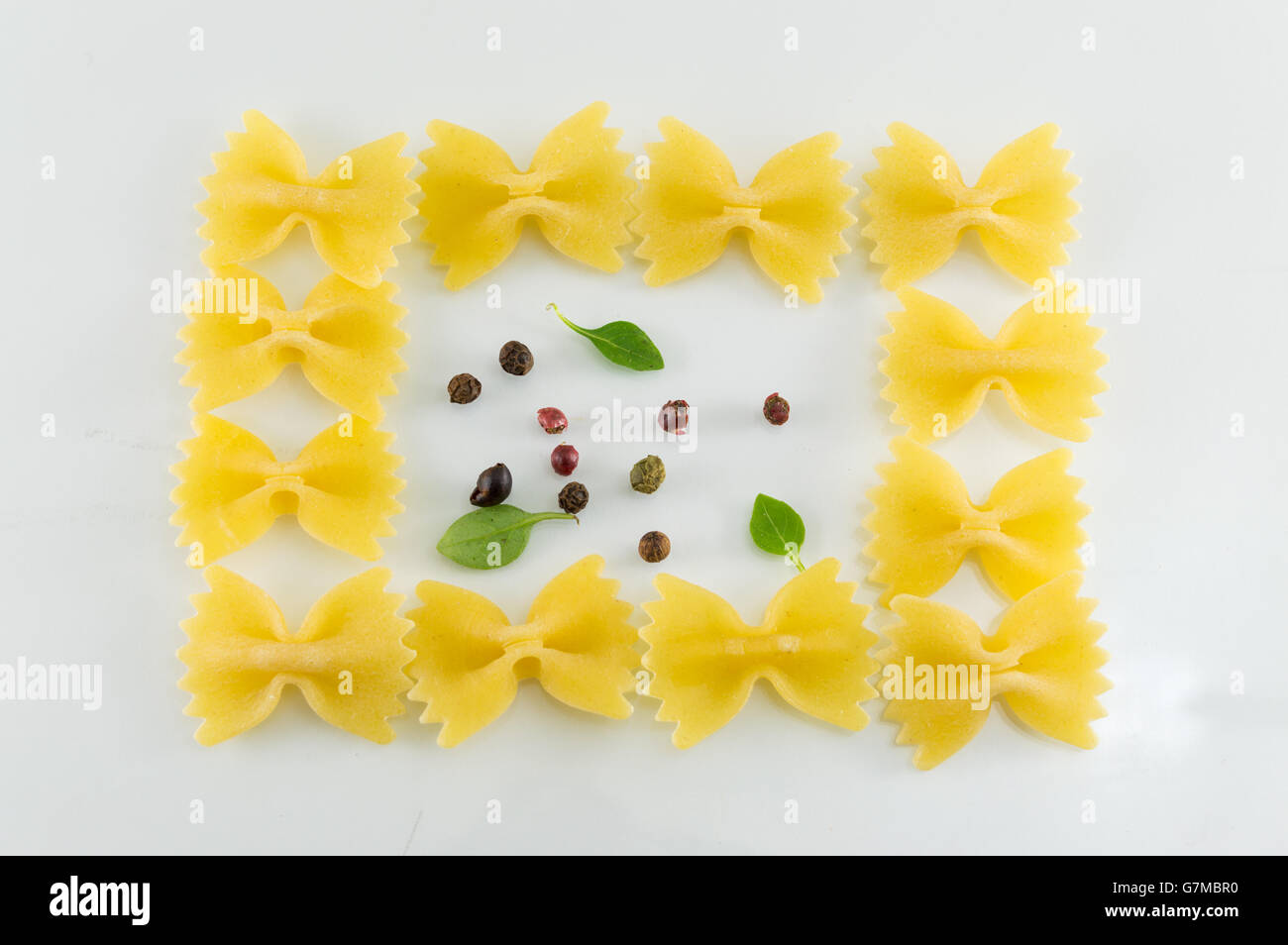 Pâtes Farfalle formant des formes sur fond blanc Banque D'Images