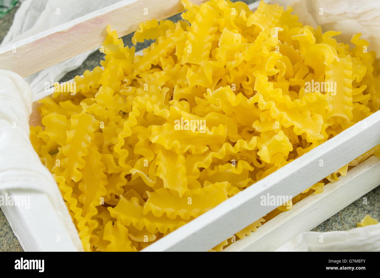 Pâtes farfalle papillon non cuits dans une boîte en bois Banque D'Images