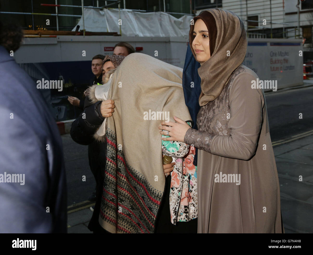 HANA Gul Khan (centre) 22, est couverte alors qu'elle quitte le Old Bailey, à Londres, après avoir été inculpée en vertu de la loi de 2000 sur le terrorisme. Banque D'Images