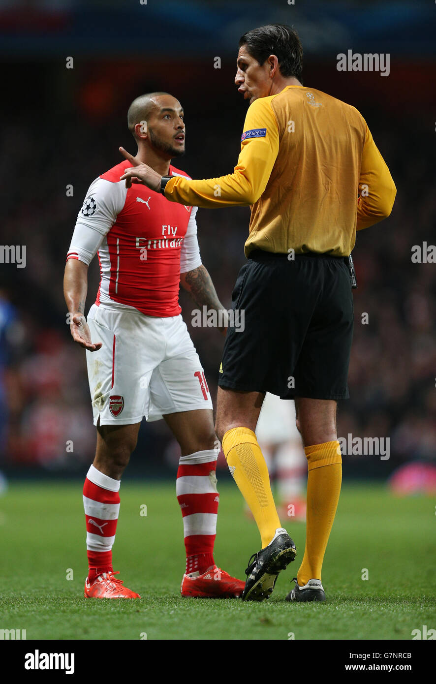 Theo Walcott d'Arsenal parle à l'arbitre Deniz Aytekin (à droite) lors du match de l'UEFA Champions League Round of 16 au stade Emirates de Londres. Banque D'Images