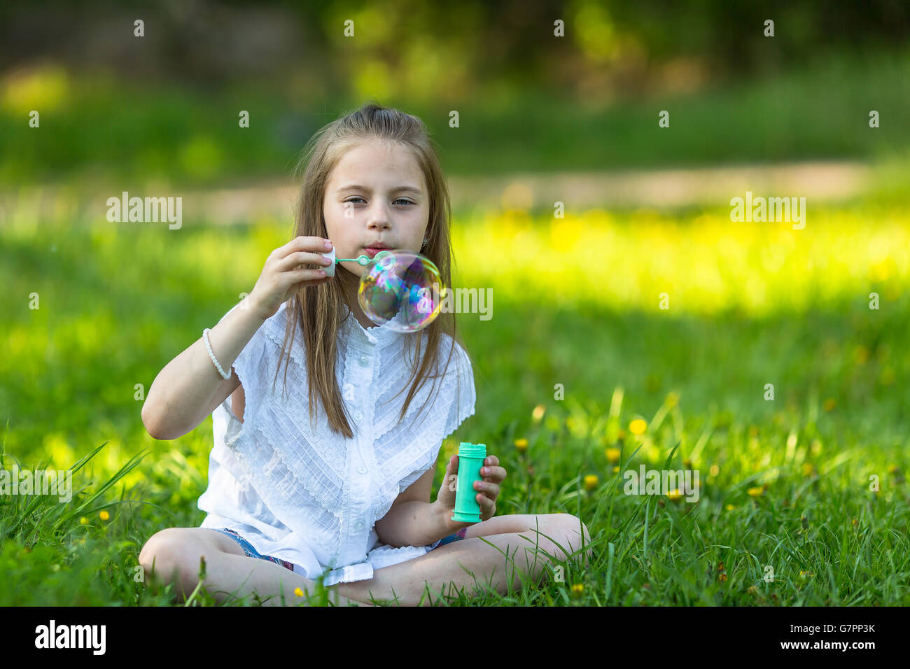 Petite fille dans Park faire des bulles. Banque D'Images