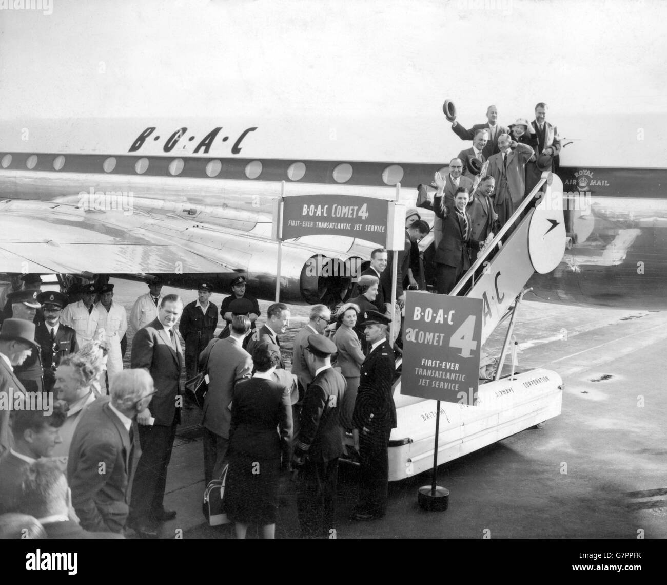 Les premiers passagers à voyager sur un service régulier de jet-liner de Londres à New York vont à bord du Comet 4 à l'aéroport de Londres. Les panneaux d'affichage proclament la victoire de la BOAC dans la course pour fournir le premier service de jet transatlantique. Le vol Comet est bien en avance sur la date annoncée par Pan American Airways pour le début de son service Boeing 707. Banque D'Images