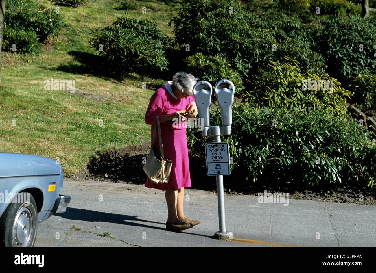 Femme plus obtenir des crédits de son sac pour payer un parcomètre Banque D'Images