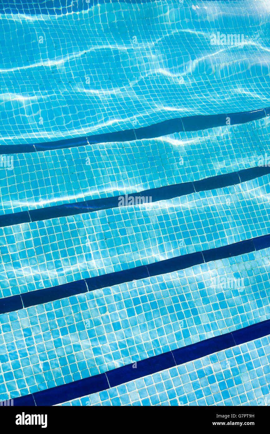 Détail d'une piscine avec la lumière du soleil reflétant sur l'eau. Banque D'Images