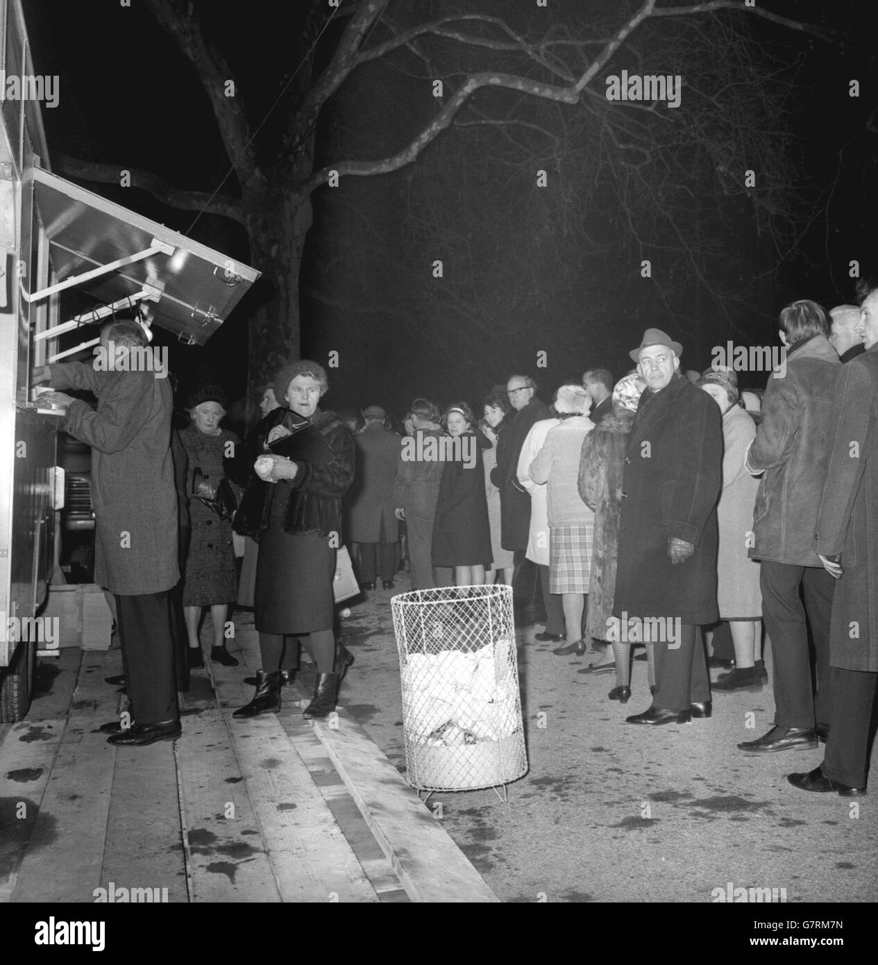 Vers la fin de leur longue vigile dans une nuit froide de janvier, les membres de la file d'attente reçoivent gratuitement des tasses de thé d'une fourgonnette WVS dans les jardins de la tour Victoria, près du Parlement à Londres.Il y a encore une longue attente, même pour ces personnes avant qu'elles atteignent l'entrée de St Stephen et sont en mesure de déposer devant le bier de Sir Winston Churchill, imposition-dans-l'État à Westminster Hall. Banque D'Images