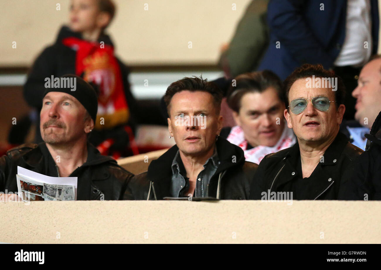 L-R: The Edge, Larry Mullen Jr et Bono, membres du groupe de rock irlandais U2 regardent le jeu depuis les stands. Banque D'Images