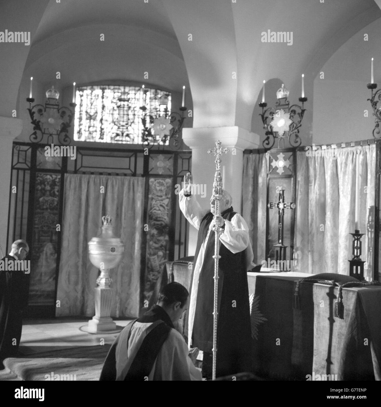 Le Dr Arthur Michael Ramsey donne sa bénédiction pour la première fois en tant qu'archevêque de Canterbury de l'autel de la chapelle de l'ordre de l'Empire britannique dans la crypte de la cathédrale Saint-Paul, Londres. C'était son premier acte en tant que nouvel archevêque de Canterbury, et est arrivé à la fin de la cérémonie de confirmation de son élection, qui a été effectuée par les Commissaires royaux (l'évêque de Londres et huit évêques diocésains) au nom de la Reine. Le Dr Ramsey, le 100e archevêque de Canterbury, sera entronisé à la cathédrale de Canterbury. Il était l'ancien archevêque de York. Banque D'Images