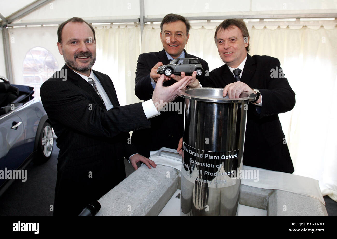 Le Dr Anton Heiss (à gauche), directeur général de l'usine du groupe BMW, place un modèle Mini dans une capsule temporelle avec le Dr Norbert Reithofer (au centre) et le député d'Oxford Andrew Smith. Banque D'Images