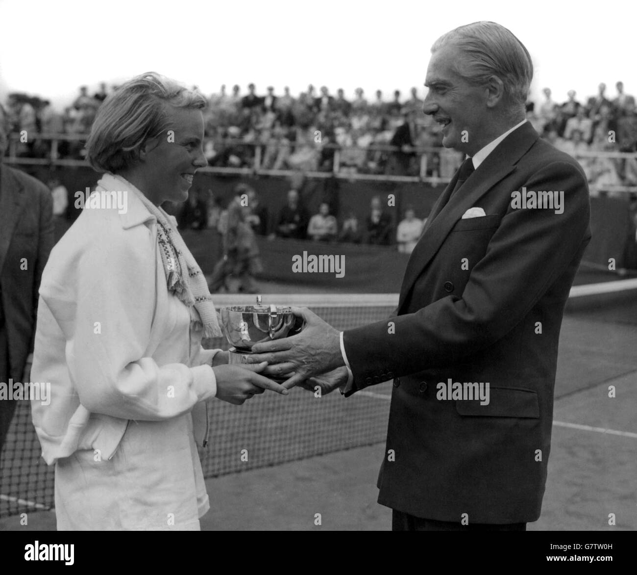 Sir Anthony Eden, Premier ministre, présente la coupe du défi de la barbe de trois jours à Ann Haydon, une écolière de Birmingham, âgée de 16 ans, après avoir remporté la finale des célibataires de la jeune fille à Wimbledon.Ann, qui était titulaire du titre, défait S. M. Armstrong. Banque D'Images