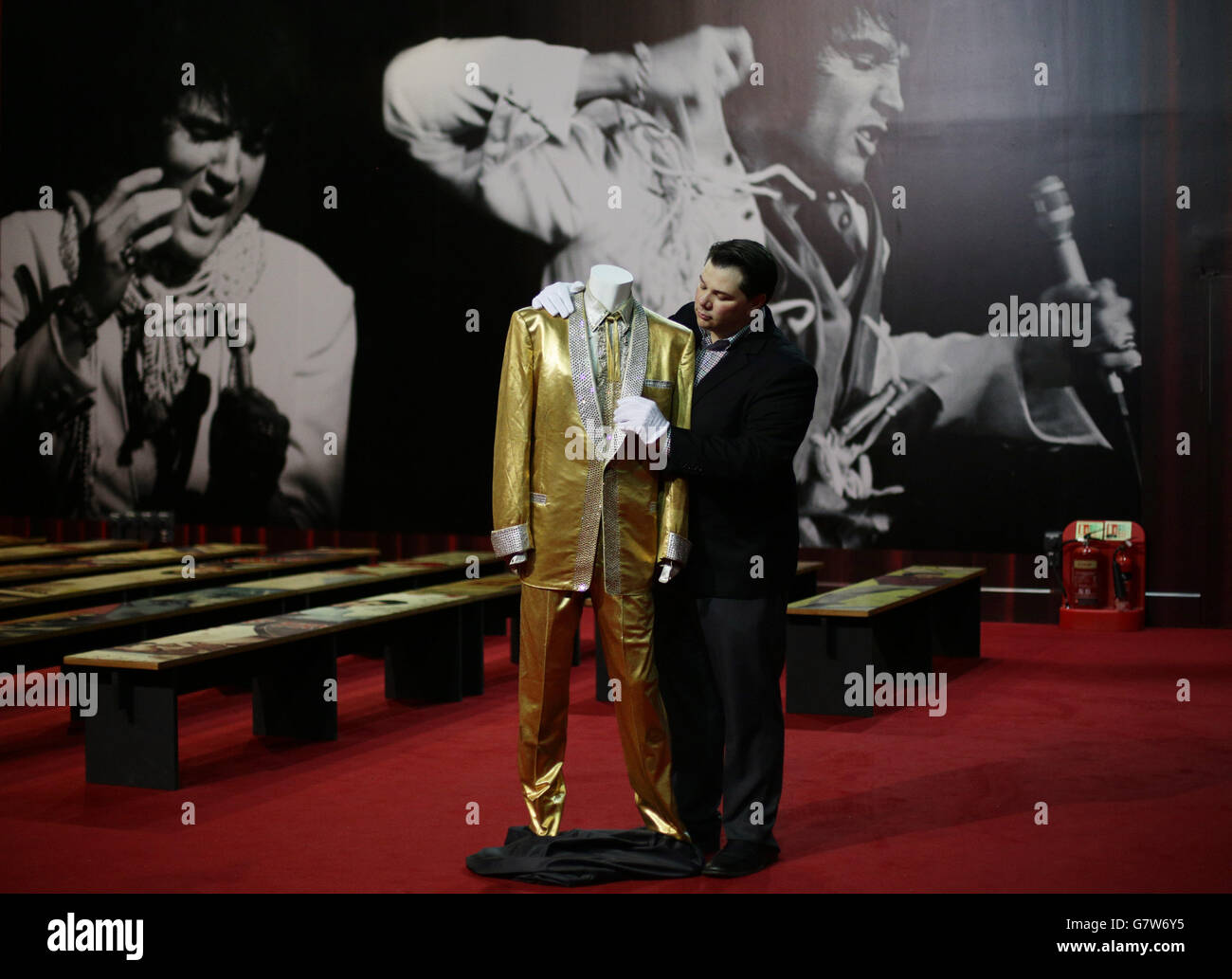 Kevin Kern, directeur de Graceland, à côté du costume d'or d'Elvis Presley, porté par le chanteur sur la couverture de son album « 50,000,000 Elvis fans can't be Wrong », à l'exposition Elvis 02, à l'O2 à Londres. Banque D'Images