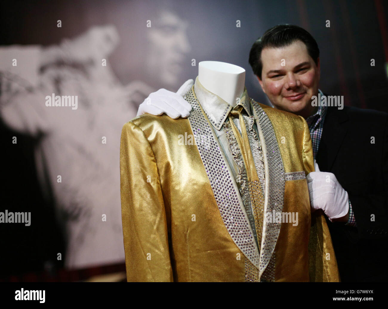 Kevin Kern, directeur de Graceland, à côté du costume d'or d'Elvis Presley, porté par le chanteur sur la couverture de son album « 50,000,000 Elvis fans can't be Wrong », à l'exposition Elvis 02, à l'O2 à Londres. Banque D'Images